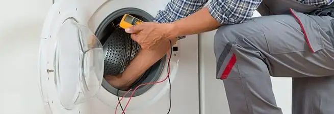 Dryer repair technician inspecting and repairing a clothes dryer in Pembroke Pines, FL