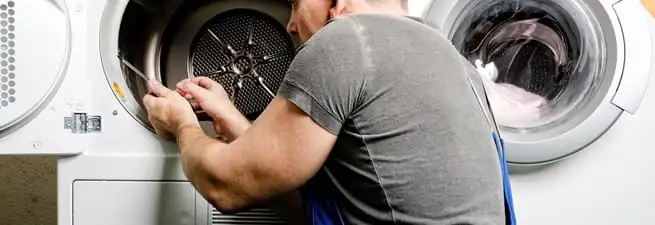 Dryer repair technician fixing a clothes dryer drum in Pembroke Pines, FL