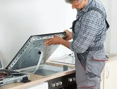 Appliance repair technician installing a built-in cooktop in Pembroke Pines, FL