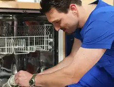 Dishwasher repair technician inspecting and servicing an open dishwasher in Pembroke Pines, FL
