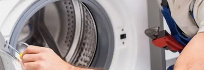 Appliance technician repairing a clothes dryer drum and internal parts in Pembroke Pines, FL