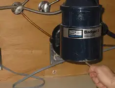 Garbage disposal repair technician tightening the mounting ring under a sink in Pembroke Pines, FL