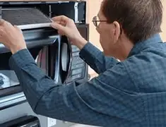 Appliance repair technician replacing a microwave vent filter in Pembroke Pines, FL