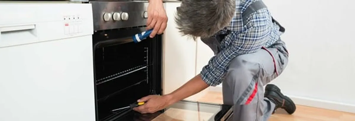 Oven repair technician inspecting and servicing an electric oven in Pembroke Pines, FL
