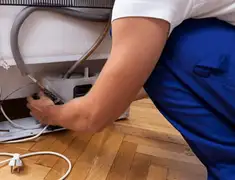 Appliance repair technician fixing refrigerator water line and connections in Pembroke Pines, FL