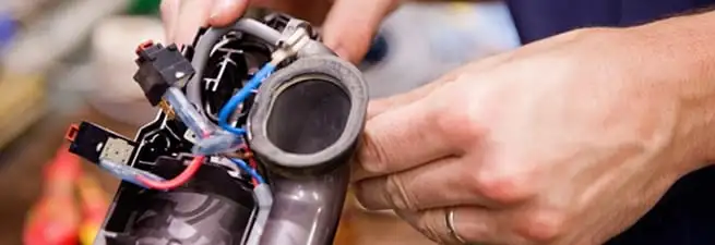 Vacuum repair technician reconnecting wiring and components in Pembroke Pines, FL