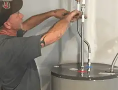 Water heater repair technician tightening supply line connections in Pembroke Pines, FL